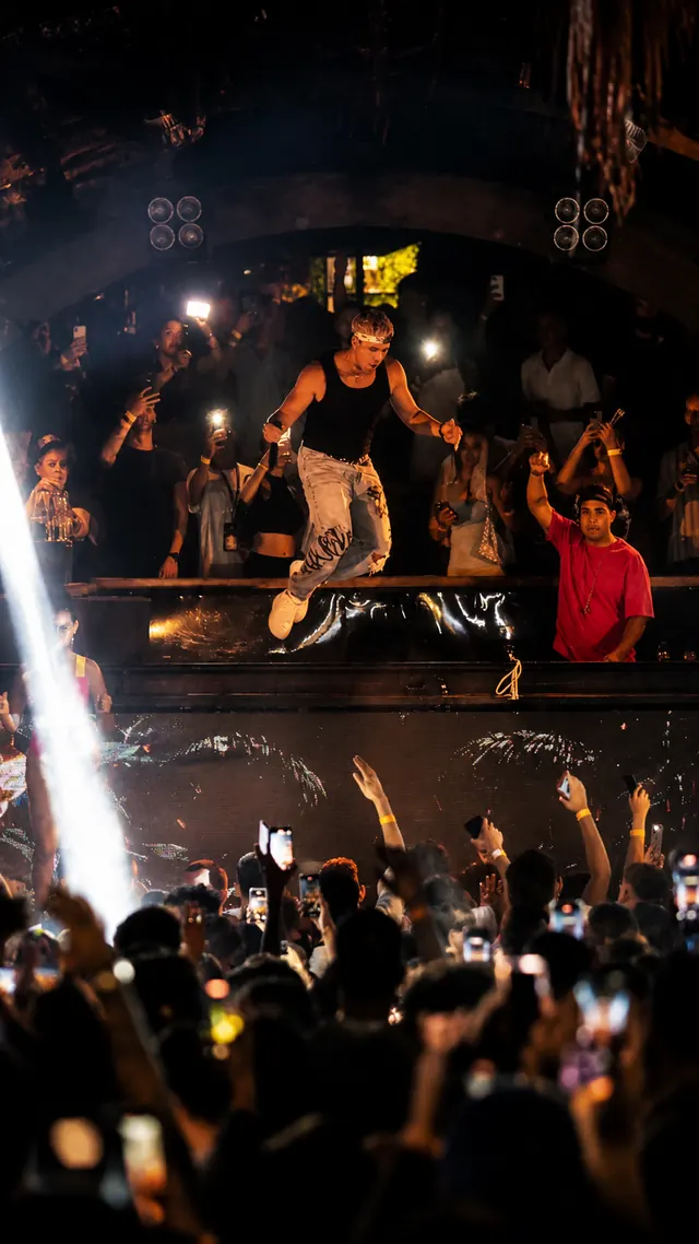 JK on the booth above a packed crowd filming him, vertical clip