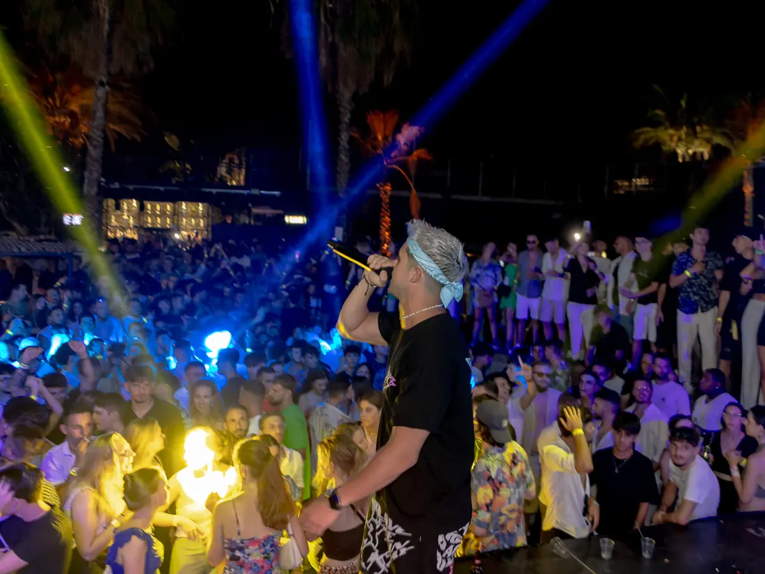 JK pinchando en una fiesta diurna al aire libre en Malta con mucho público